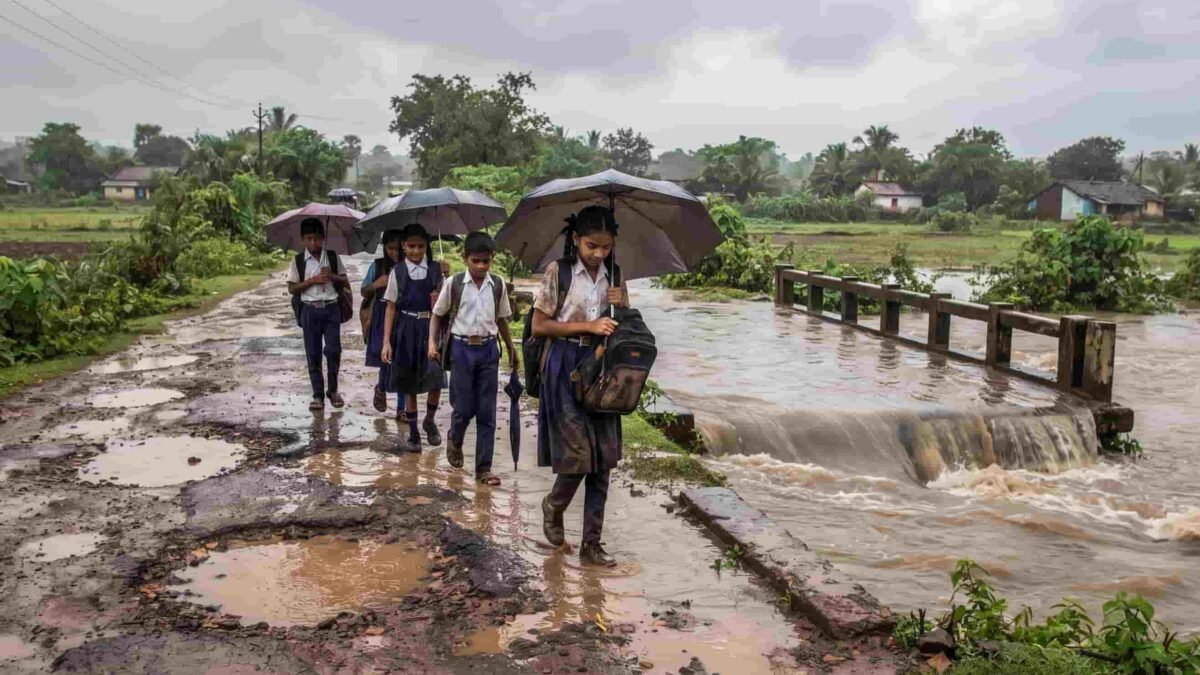 : Students navigating a flooded bridge and pothole-riddled road on their way to school in Dharashiv.