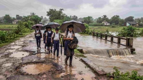 : Students navigating a flooded bridge and pothole-riddled road on their way to school in Dharashiv.